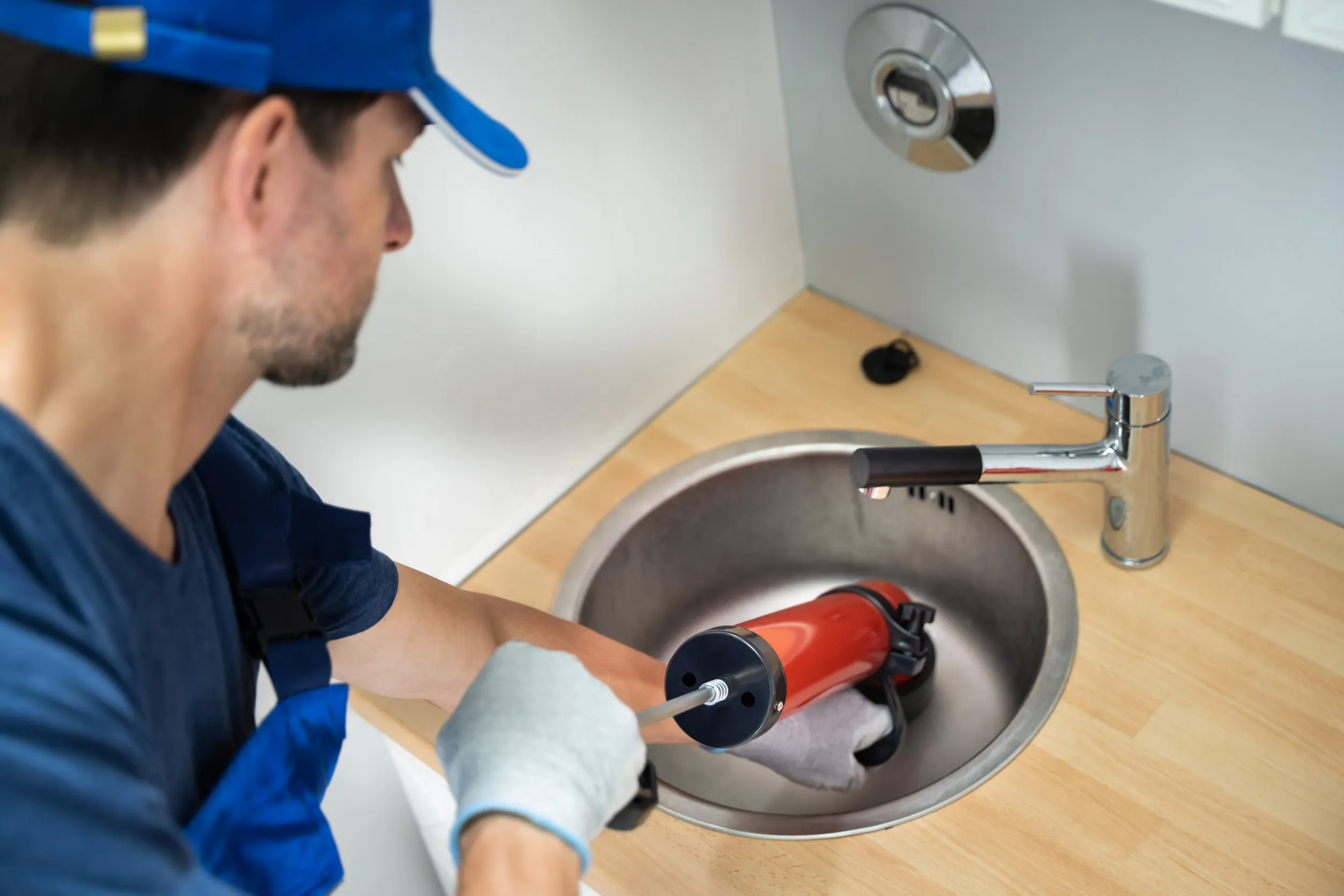 Plumber Cleaning Drain And Sink Using Pump
